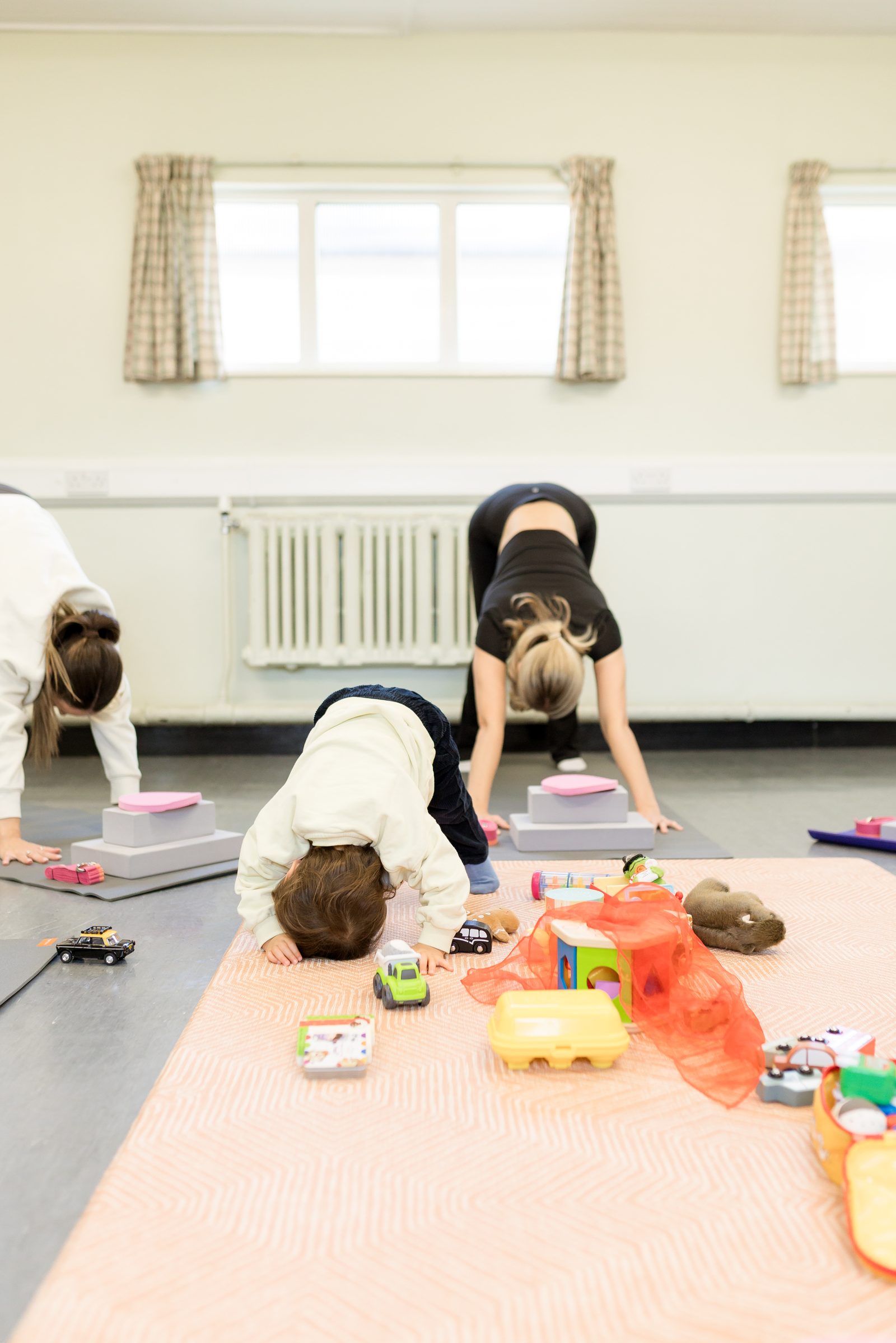 Downward dog poses with a curious baby in the foreground